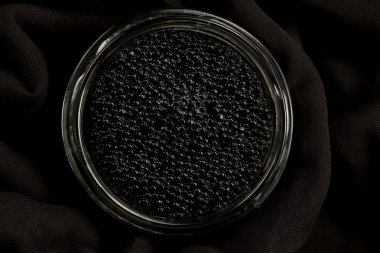 black Beluga caviar in glass jar on wooden background clipart