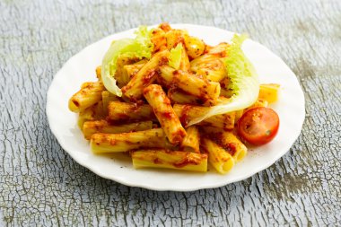 ahşap arka plan üzerinde domates soslu makarna beyaz tabak. sağlıklı beslenme