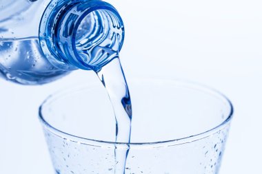 bir zarif cam su dökerek su beyaz zemin üzerine bırakır. Makro