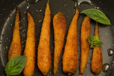 Bütün kavrulmuş havuç ile bir tavada baharat. Sağlıklı yemek