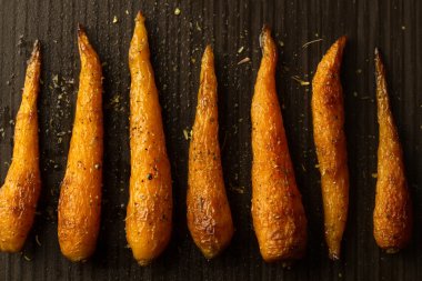 Bütün kavrulmuş havuç ile bir tavada baharat. Sağlıklı yemek