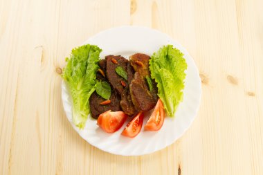 sebze ve otlar ile ahşap arka plan üzerinde beyaz tabakta domuz kızartma