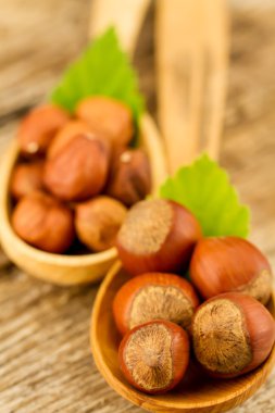 hazelnuts with leaves on old wooden background. Healthy vegetarian food