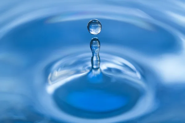 Vattendroppe falla i vatten gör en droplet splash — Stockfoto