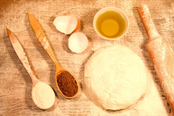 Homemade baking. Fresh dough for pastry, kitchen rolling pin, spoon flour, broken eggs on a chopping Board — Stock Photo, Image