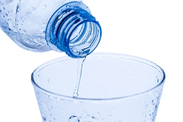 Versando acqua in un elegante bicchiere d'acqua gocce su fondo bianco. Macro — Foto Stock