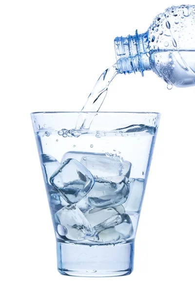 buz ve su ile zarif bir bardakta su dökerek beyaz arka plan üzerinde damla