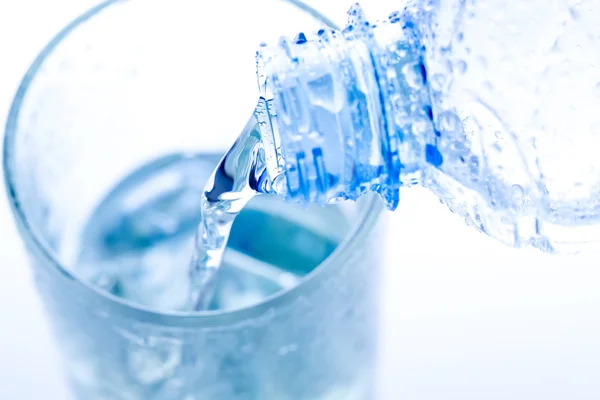 Pouring water in an elegant glass with ice and water drops. Macro — Stock Photo, Image