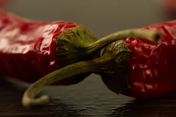 Peperoncino rosso su fondo scuro con gocce d'acqua, macro — Foto Stock