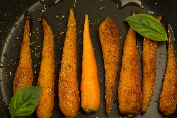 Zanahorias asadas enteras con especias en una sartén. Comida vegetariana saludable — Foto de Stock