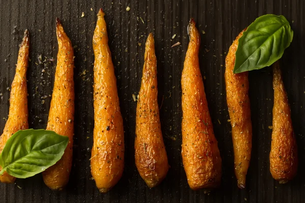 Bütün kavrulmuş havuç ile bir tavada baharat. Sağlıklı yemek