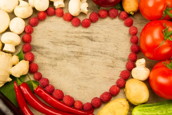 Zöldség az alakja a szív, a fából készült háttér, vegetáriánus ételek igényelhetők. Az egészséges táplálkozás — Stock Fotó