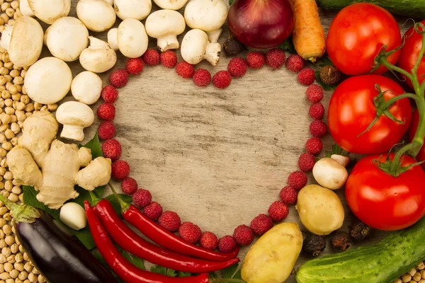 Zöldség az alakja a szív, a fából készült háttér, vegetáriánus ételek igényelhetők. Az egészséges táplálkozás — Stock Fotó