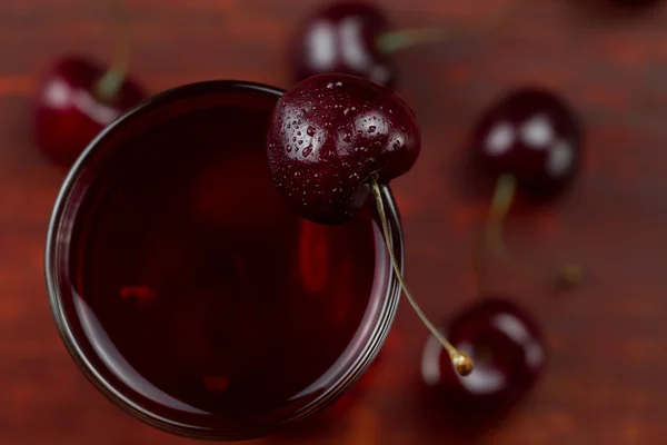 Cereja de suco com bagas maduras em fundo de madeira. Uma dieta saudável — Fotografia de Stock