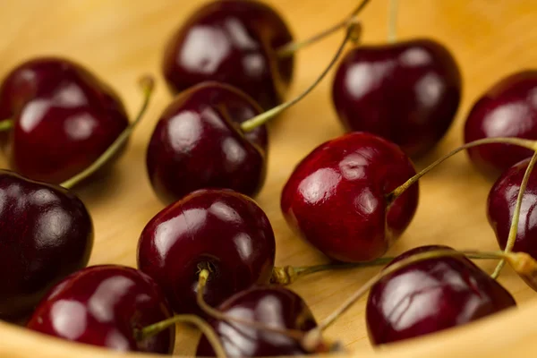 Cereza fresca madura en un plato de madera —  Fotos de Stock