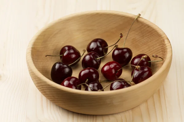 Fresh ripe cherry in a wooden plate — Stok fotoğraf