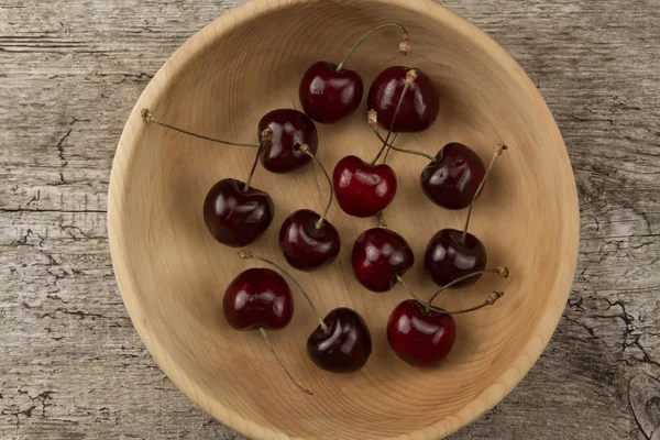 Fresh ripe cherry in a wooden plate — Stock fotografie