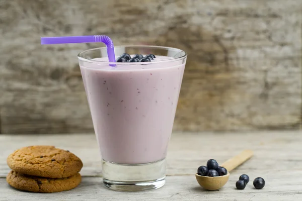 Frullato di mirtillo con bacche, biscotti di avena su sfondo di legno. Cibo vegetariano sano, dieta . — Foto Stock