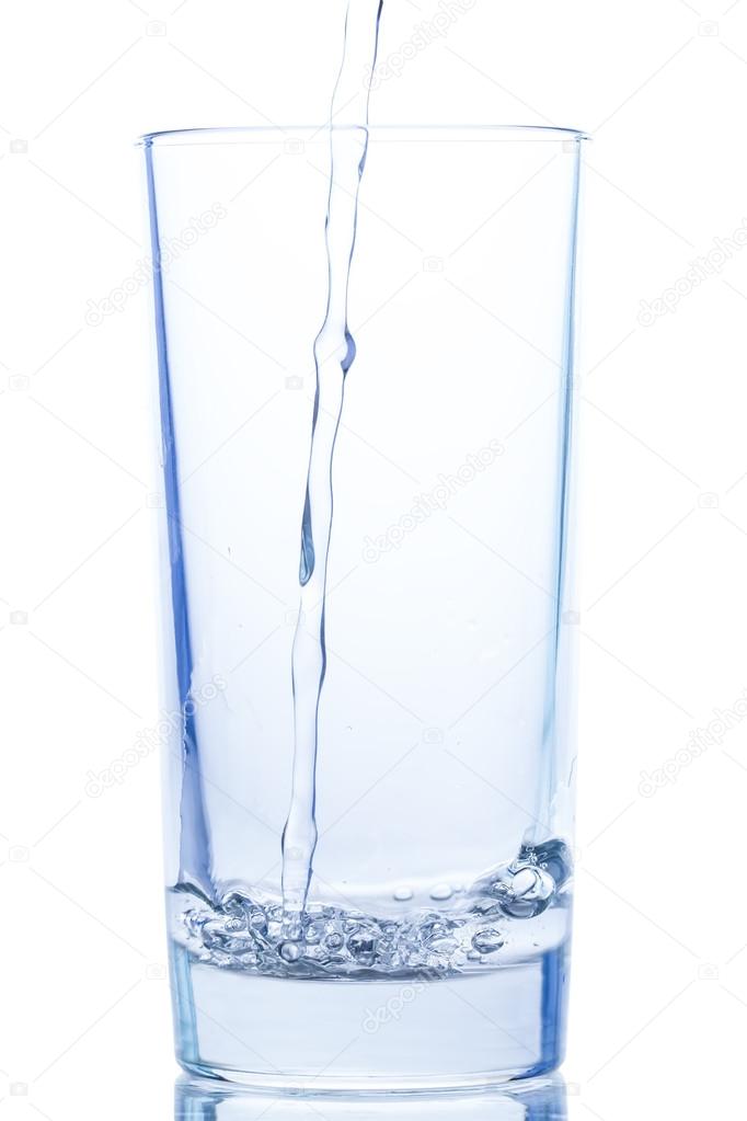 pouring water in an elegant glass and water drops on white background