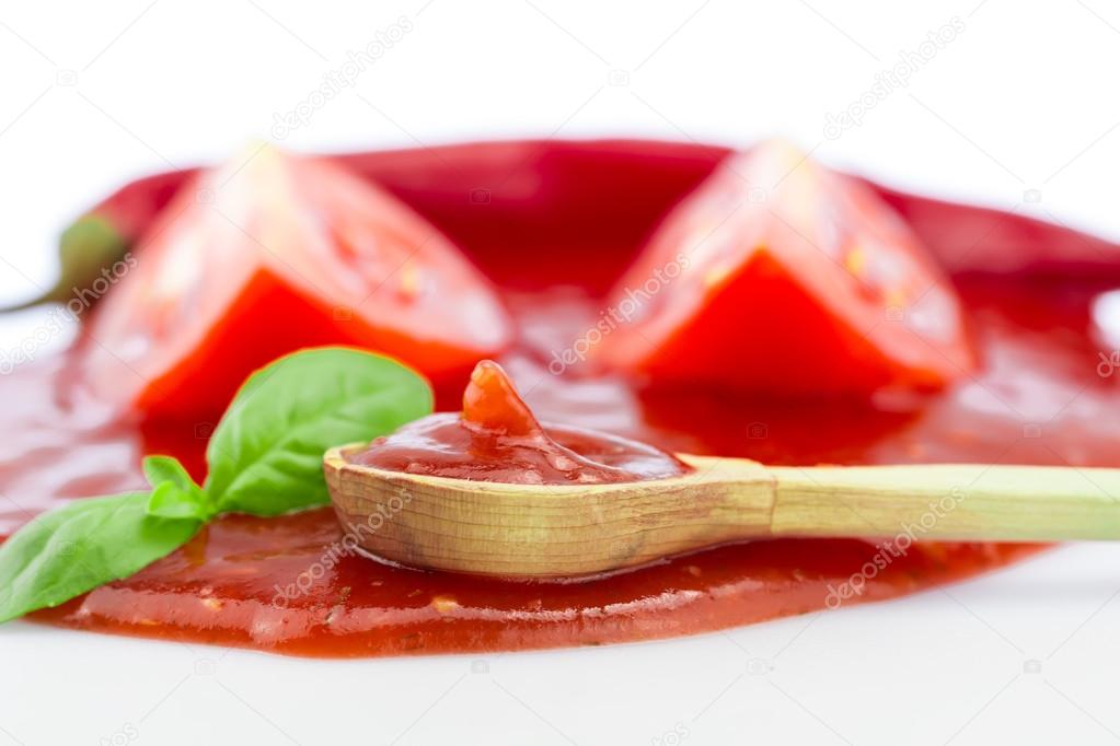 Tomato ketchup in a wooden spoon on a white background. Homemade, healthy vegetarian food