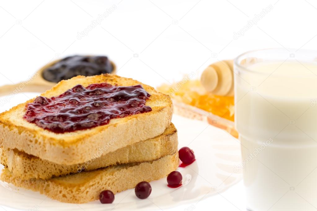 fresh french toast with honey and jam on a white plate with berries on a white background. healthy diet