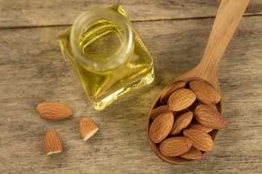 bir kaşık ve bir kavanoz ahşap zemin üzerine yağda soyulmuş badem