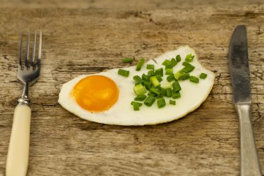 ahşap bir zemin üzerine soğan ile tepesinde kızarmış yumurta