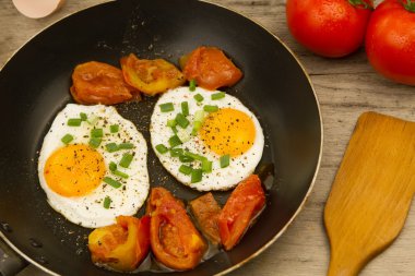 soğan ve domates ahşap arka plan üzerinde tepesinde kızarmış yumurta