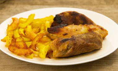 ahşap arka plan üzerinde beyaz plaka üzerinde kızarmış Domuz kızartması ile birkaç adet