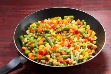 ahşap arka plan üzerinde tavada sebze karışımı