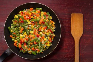 ahşap arka plan üzerinde tavada sebze karışımı