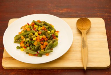 ahşap arka plan üzerinde beyaz tabakta karışık sebze