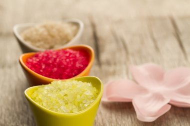 Colorful sea bath salts on wooden background. Spa, aromatherapy.