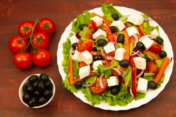 Madlavning sommer Græsk salat på træbaggrund - Stock-foto