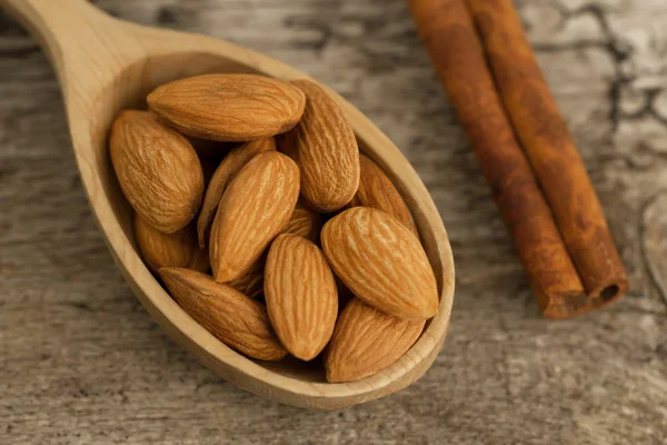 Peeled almonds in spoon on wooden background. For vegetarians — Stock Photo, Image