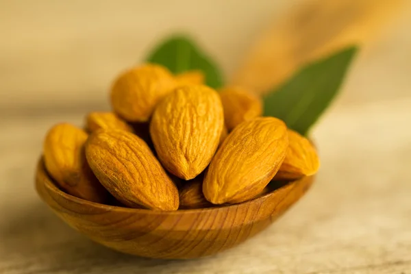Terkelupas almond dalam daun sendok c di atas meja kayu — Stok Foto