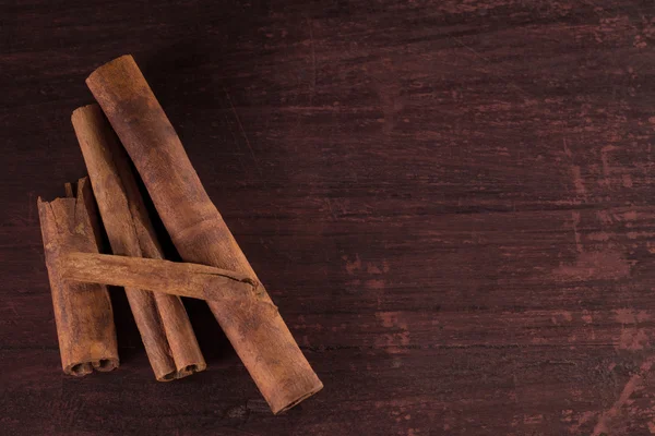 Whole cinnamon sticks on wooden background — Stock Photo, Image