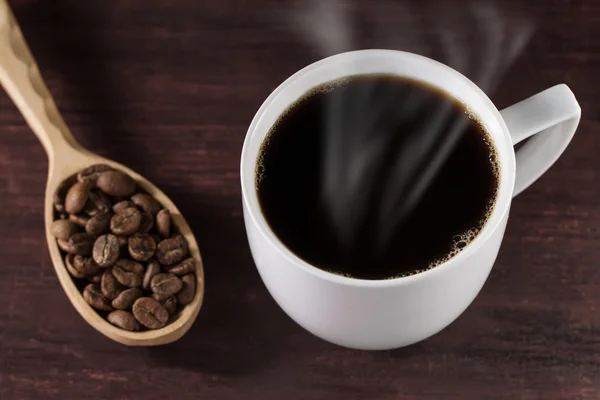 Tazza di caffè francese sul tavolo di legno e un cucchiaio pieno di fagioli — Foto Stock