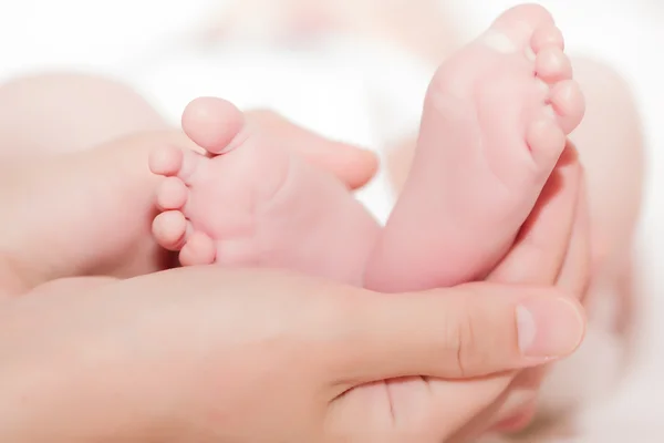 Concept d'amour et de famille. mains de la mère et du bébé pied — Photo