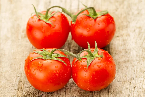 Few red tomatoes branch on wooden background — Stock Photo, Image