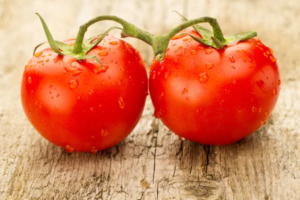 Few red tomatoes branch on wooden background — Stock Photo, Image