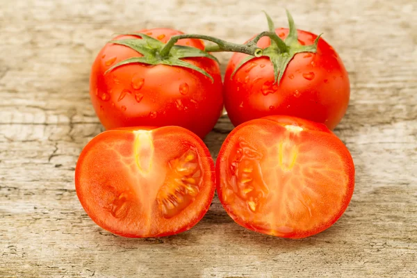 Few red tomatoes branch on wooden background — Stock Photo, Image