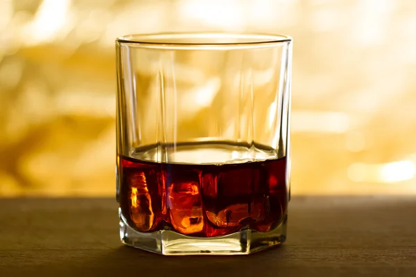 Whiskey with ice on a wooden table — Stock Photo, Image