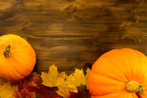 Yellow ripe pumpkin, maple leaves on wooden background. Thanksgiving, autumn. — Stock Photo, Image