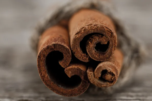 Cinnamon sticks on old wooden background. Macro — Stock Photo, Image