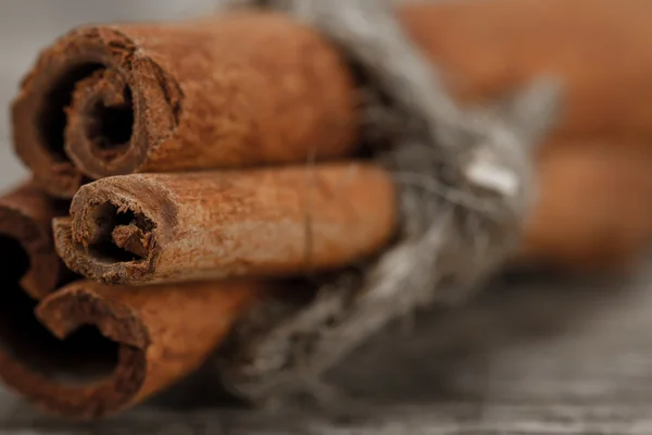 Cinnamon sticks on old wooden background. Macro — Stock Photo, Image
