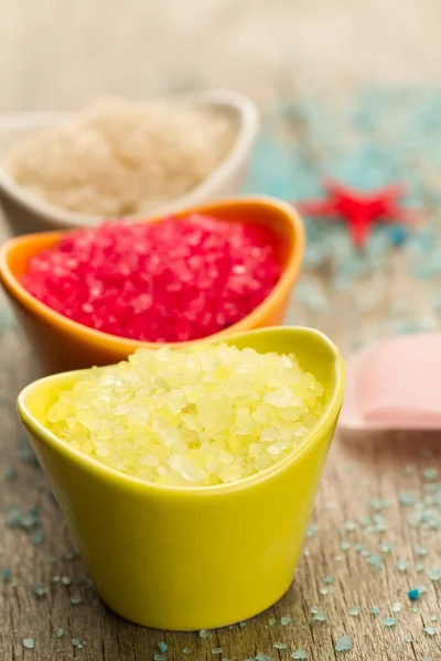 Colorful sea salts and seashells for the bathroom on wooden background. Spa, aromatherapy. — Stock Photo, Image