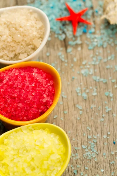 Colorful sea salts and seashells for the bathroom on wooden background. Spa, aromatherapy. — Stock Photo, Image