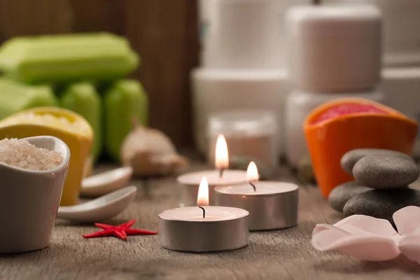 Composición del spa con sal marina, velas, jabón, conchas, cremas para la cara sobre fondo de madera. Aromaterapia . — Foto de Stock