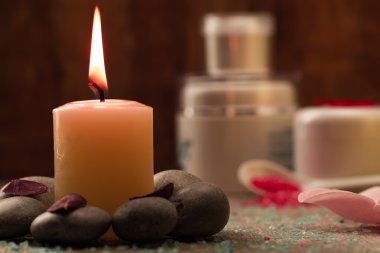 Spa composition with sea salt, candles, soap, shells, creams for face on wooden background. Aromatherapy.